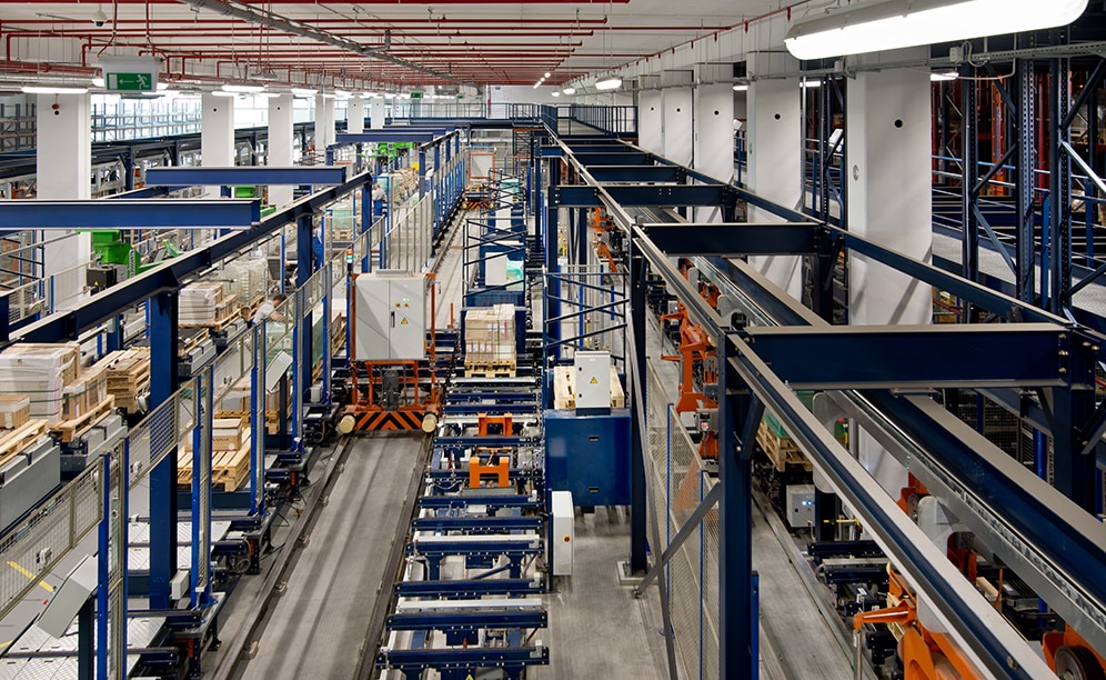 Dos lanzaderas dobles organizan esta área y distribuyen los palets entre los transportadores de entrada, las estaciones de espera y los puestos de picking Dos lanzaderas dobles organizan esta área y distribuyen los palets entre los transportadores de entrada, las estaciones de espera y los puestos de picking