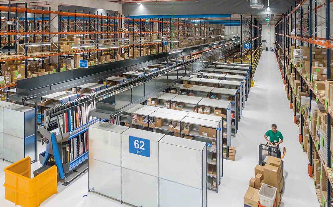 Un operario realiza tareas de picking en una bodega ayudado por una transpallet